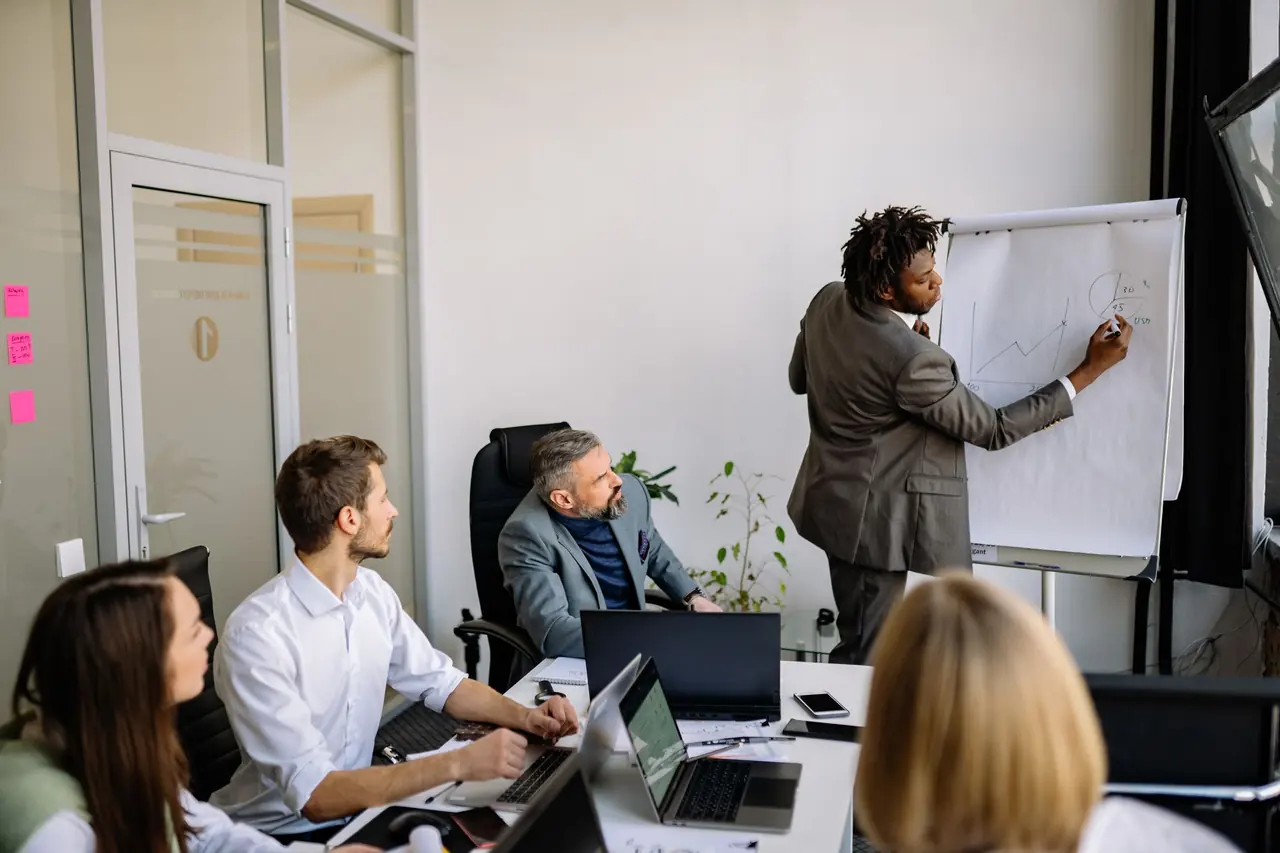 A presenter leading a strategy meeting at a flip chart