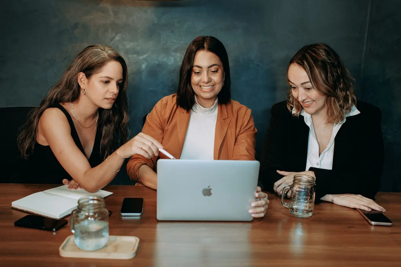 Three professionals collaborating over a laptop