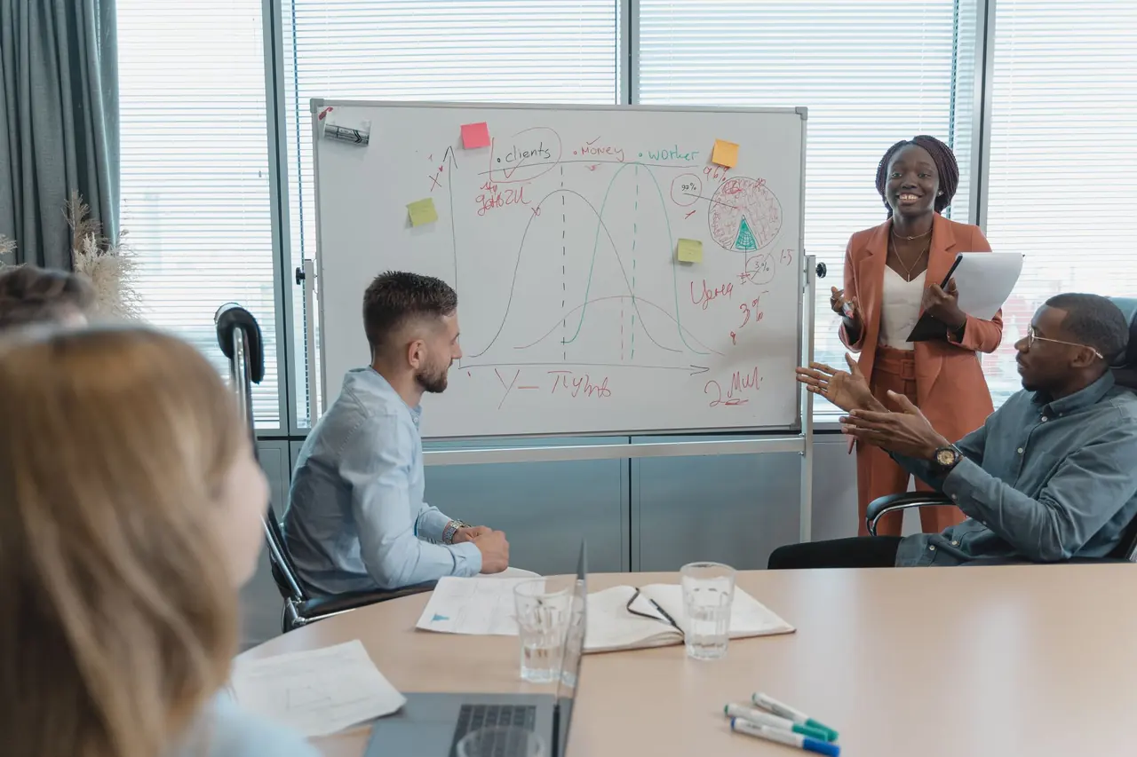 A team meeting around a whiteboard in a conference room